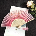 Pink wooden folding fan with cherry blossom pattern and matching pink tassel accessory - Cherry Blossoms Falling - Pink