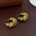 Gros plan de boucles d'oreilles créoles dorées multicouches en métal sur cuir - Style de Gamme Torsadée Dorée (HE10656)