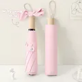 Pink foldable sun umbrella with natural wood handle and bow detail in a hard storage case - Light Pink
