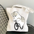White canvas tote bag featuring a cute grey and white cat riding a bicycle print - Cat Cycling A
