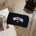 Gros plan du bandeau en tricot noir avec broderie Boston sur une table en bois - Noir