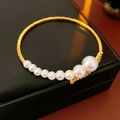 Close-up of elegant gold open cuff bracelet with gradient pearls and sparkling rhinestones - Pearl Rhinestone Open Bangle / Gold