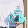 Detail of 600ml mint green TV-shaped kids water bottle with bunny ears and strap - 600ml / Blue