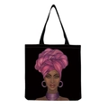 Detail of reusable black canvas tote bag featuring an ethnic portrait art print - Afro Lady Portrait-Pink Wrapped Turban