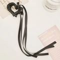 Dettaglio di una pinza per capelli a cuore nera con lunghi nastri su sfondo bianco - 6*6cm / Nero