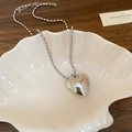 Minimalistische silberne Herzanhänger-Halskette mit Perlenkette auf weißer Schale - Silber