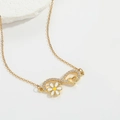 Makro-Detail der goldenen Unendlichkeit-Halskette mit Gänseblümchen und Herz-Zirkonia - Weiße Blume