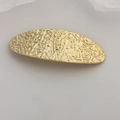 Elegant gold spring hair clip featuring unique hammered texture and lava metal finish - Gold Patterned Oval Clip