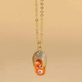 Gros plan détaillé du pendentif tong dorée avec émail orange et motif de l'œil protecteur - Mauvais Œil Orange