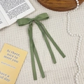 Classic green ribbon bow hair clip in soft satin fabric displayed on waffle texture fabric - Green