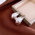Detail of glossy silver teardrop earrings placed on silk fabric and jewelry box - Silver Needle - Silver Curved Teardrop Stud Earrings