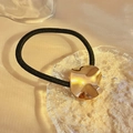 Coletero minimalista con un accesorio de metal dorado con forma de onda brillante - Disco Ondulado Dorado