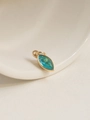 Detail of an 18K gold plated oval pendant with a marquise blue zircon on a ceramic dish - December/Dark Blue