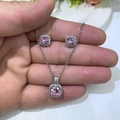 Detail of pink zircon necklace and square stud earrings jewelry set held by hand - Pink