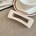 Detail of a minimalist cream rectangular hollow hair claw clip on felt background - Pink