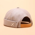 Beige Dockermütze ohne Krempe mit silbernem X-Metall-Logo und braunem Lederband - X Metallanhänger Khaki