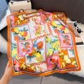 Detailed close-up of a vibrant orange silk-style square scarf with tropical fruit patterns - 70*70cm / Orange Border Fruit