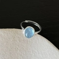 Detailed macro shot of an adjustable silver ring with a light blue oval stone insert - J3678 Light Blue Gem Open
