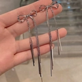 Macro detail of silver bow earrings with long metallic tassel chains for women - Bow Combination / Silver