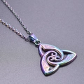 Macro shot of iridescent rainbow stainless steel Celtic knot pendant with intricate engraving - Pendant Necklace / Rainbow
