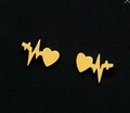 Golden heartbeat studs with heart and cross motifs on a matte black background - Gold