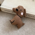Detailopname van een bruine stoffen hondenbroche met borduursel op een vilten achtergrond - Bruine Hond (Eendenbek Clip)