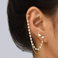 Golden heart ear cuff and stud set with pearls and chains on a model's ear - Heart Pearl Chain Gold
