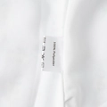 Detail shot of white care label on dress showing 100% polyester fabric and washing icons - S / White Floral