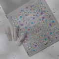 Dettaglio di adesivi per unghie con strass colorati Co-407 su unghie grigio lucido - Strass in Resina Colorata (CO-407)