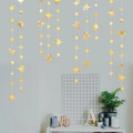 Detail van een gouden ster- en cirkelslinger hangend aan een grijze muurdecor - 1.5M ster en cirkel goud
