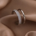 Detail of double-layer silver ring with pave-set zircons on elegant brown satin fabric - Silver