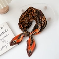 Pleated silk scarf featuring orange leopard and zebra patterns on a white desk - Orange Leopard Zebra Print
