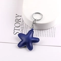Close-up of a blue leather star charm with visible stitching and silver metal keychain ring - Sapphire Blue