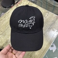 Close-up of black baseball cap with white Thai script embroidery on the front panel - Adjustable / Black