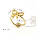 Detail showing the adjustable opening and bead ends of the gold bow knot steel ring - Hollow Bow Style (XKR0158) / Gold