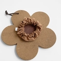 Brown fabric large scrunchie displayed on a floral cork mat over white background - Small / Caramel color