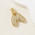 Gold plated letter M pendant necklace with sparkling cubic zirconia on beige background - Letter M