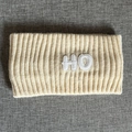 Makro-Detail von geripptem Strickstirnband in Creme mit strukturiertem HO-Patch - Beige