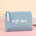 Detail of light blue canvas makeup bag with BEST DAY print and metal zipper on pink desk - Blue Letter Print