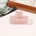 Close-up of pink marble texture hair claw clip with pearlescent finish on desk - PVC 7.5cm Rectangular - Iridescent Pink