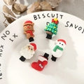 Close-up of 5pcs Christmas hair clips with Santa and snowman on a ceramic plate - Snowman Santa Sock Christmas Tree Reindeer Hair Clips 5pcs Set