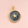 Detail of round gold pendant featuring a dark grey enamel base and star embellishment - Dark Grey Star