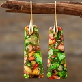 Detail of bohemian teardrop earrings with colorful stone inlay hanging on a wooden stand - Green Patterned Trapezoid