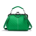 Detail of green woven texture and vintage metal kiss-lock frame on retro crossbody bag - Green