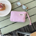 Petite trousse de maquillage à rayures roses et blanches sur table en bois - Rose Vertical