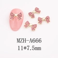 Detail view of 11x7.5mm bow-shaped pink rhinestone alloy charms on a soft pink nail - Slim Bowknot (A666)