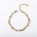 Detail of golden double-layer chain bracelet with metal beads and lobster clasp closure - 17+5cm / Cross Bead Chain + Banana Leaf Bracelet / Gold