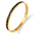 Gold stainless steel bangle with black enamel flower pattern shown at a 45-degree angle - Gold Black