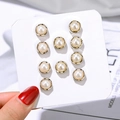 Set of 9 pairs of elegant gold-rimmed pearl studs presented on a white display card - Pearl Style