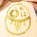 Detailopname van gouden bruidssieradenset met vintage muntstukken en kwastjesdetails - 4-Delige Set Ketting Oorbellen Armband Ring